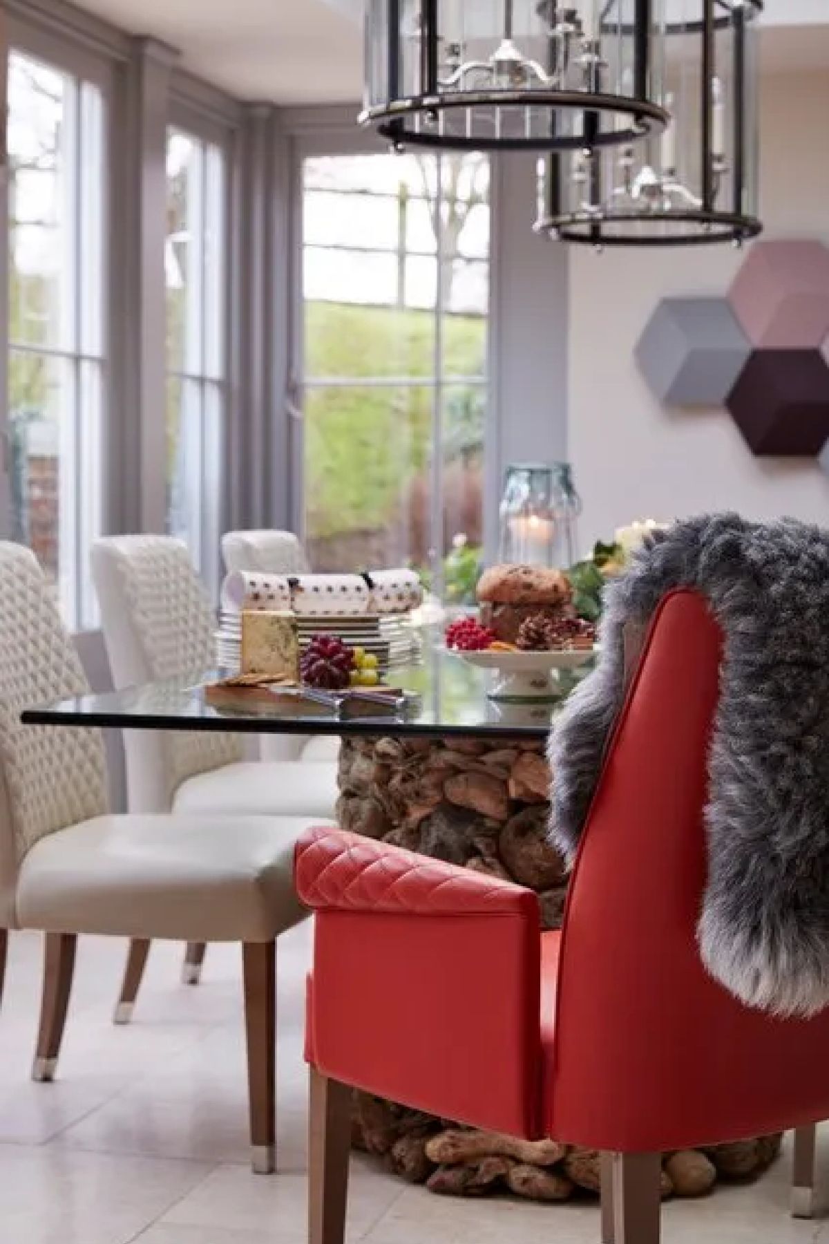 The Kitchen Orangery dining room dressed for Christmas - pendant lanterns, festive table and red accent chairs, Kent
