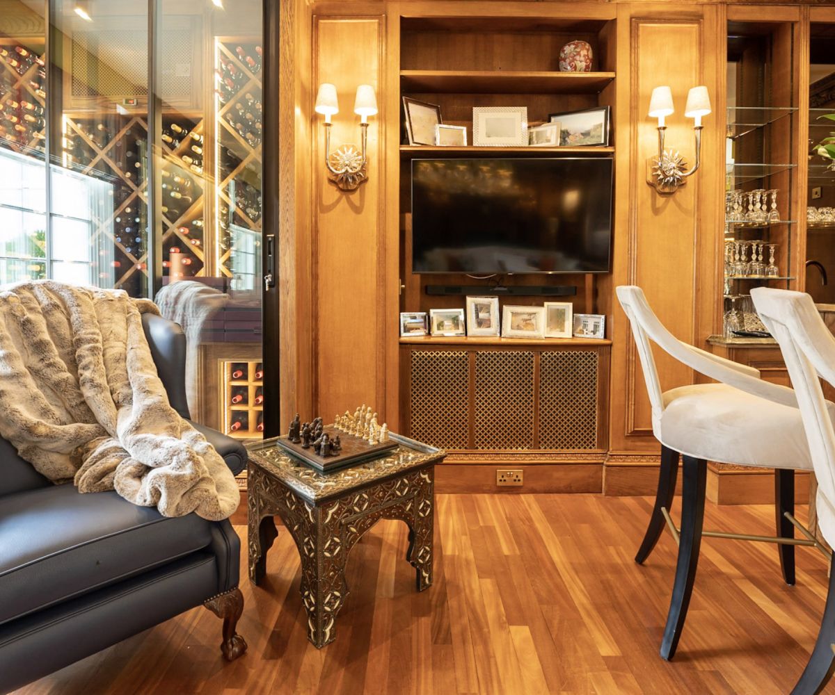A beautifully styled living room with full floor-to-ceiling shelving, artwork and comfortable seating - installation by Atlantic Interiors
