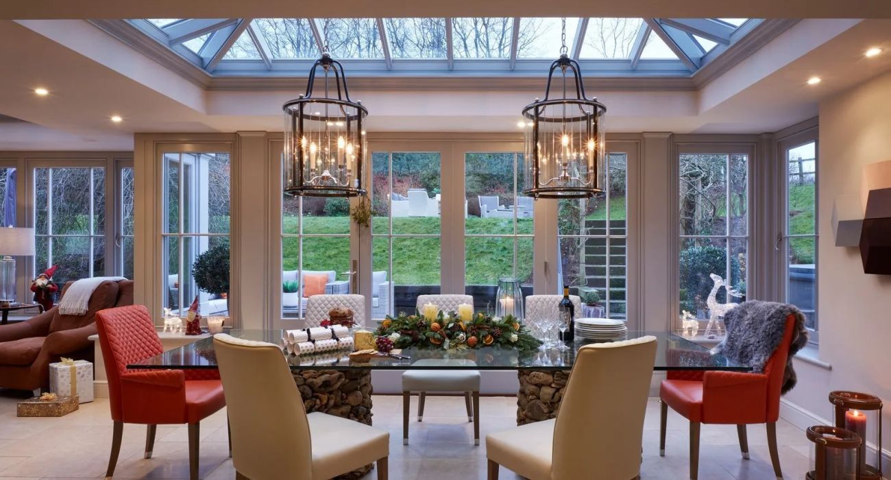 A grand open-plan kitchen and orangery with pendant lanterns and a dining area - Atlantic Interiors interior design, Kent