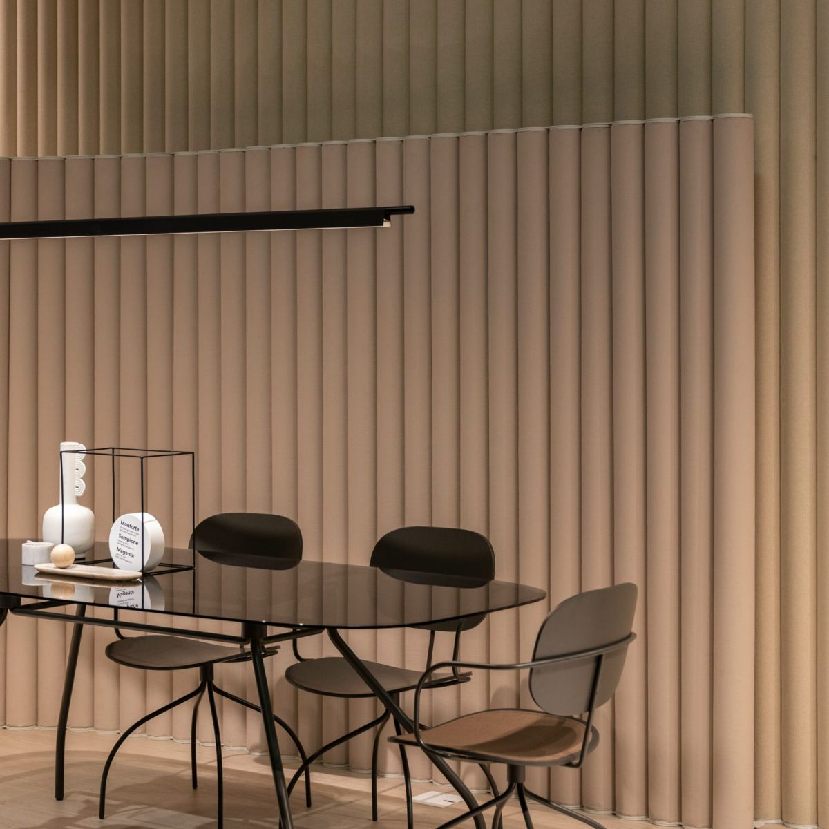 A refined commercial interior with vertical timber slat panelling and a round dining table - designed by Atlantic Interiors