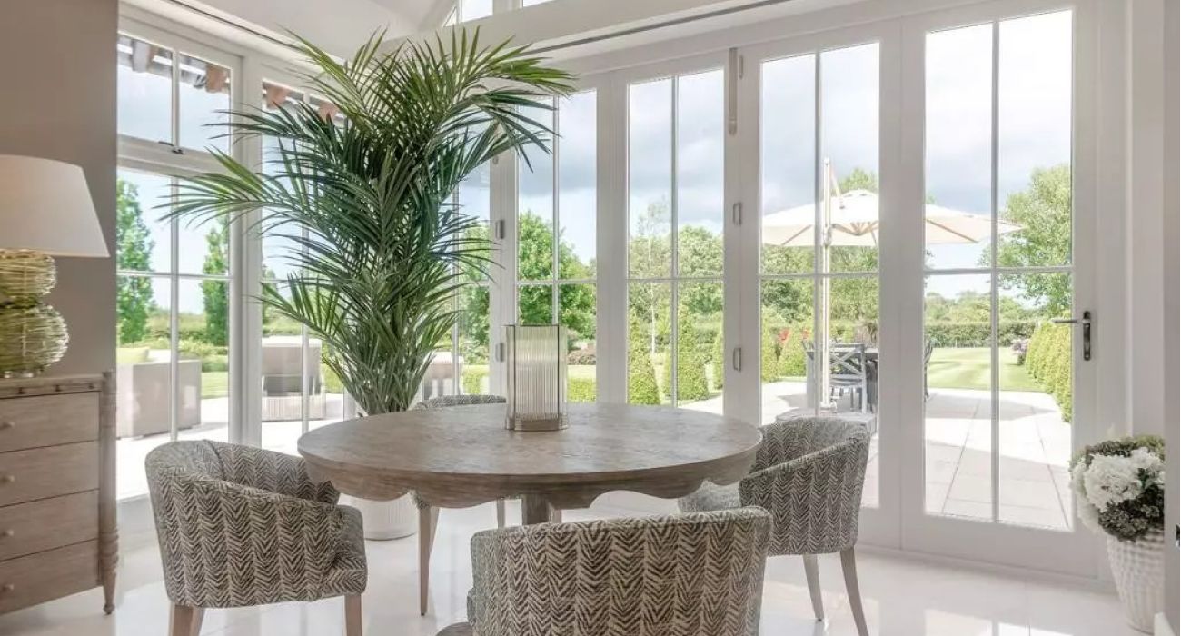 A grand open-plan kitchen and orangery with pendant lanterns and a dining area - Atlantic Interiors interior design, Kent