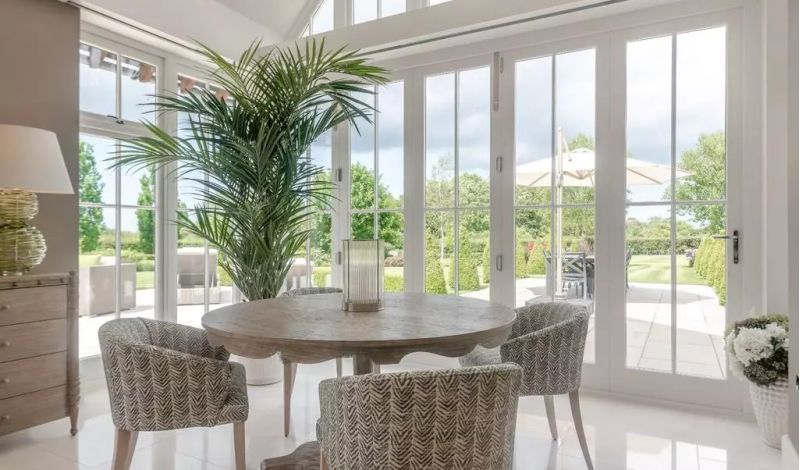 A grand open-plan kitchen and orangery with pendant lanterns and a dining area - Atlantic Interiors interior design, Kent