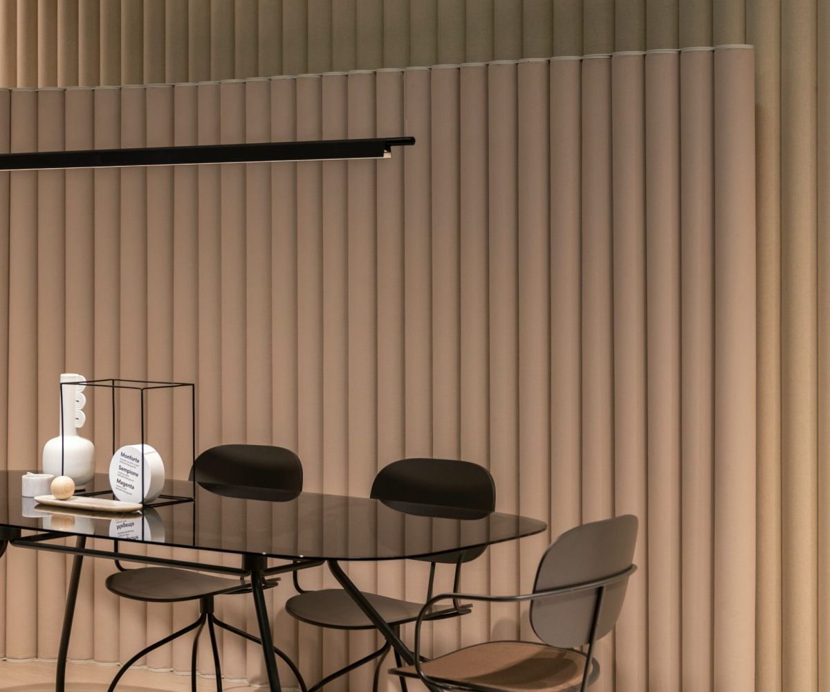 A refined commercial interior with vertical timber slat panelling and a round dining table - designed by Atlantic Interiors