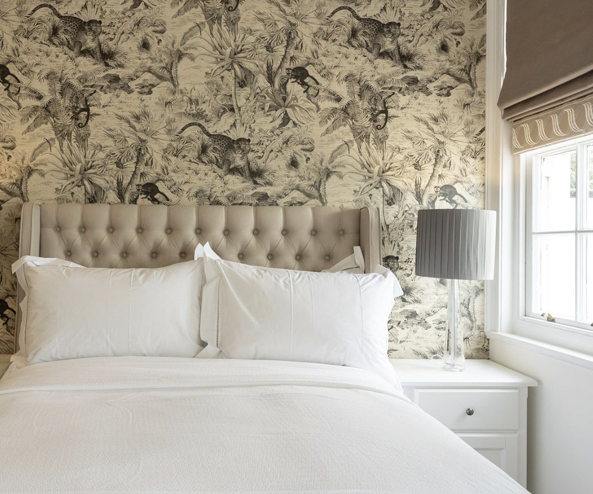 A luxury residential bedroom interior designed by Atlantic Interiors - botanical wallpaper and tufted headboard