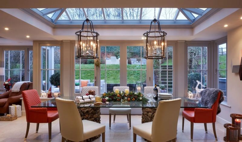 A grand open-plan kitchen and orangery with pendant lanterns and a dining area - Atlantic Interiors interior design, Kent