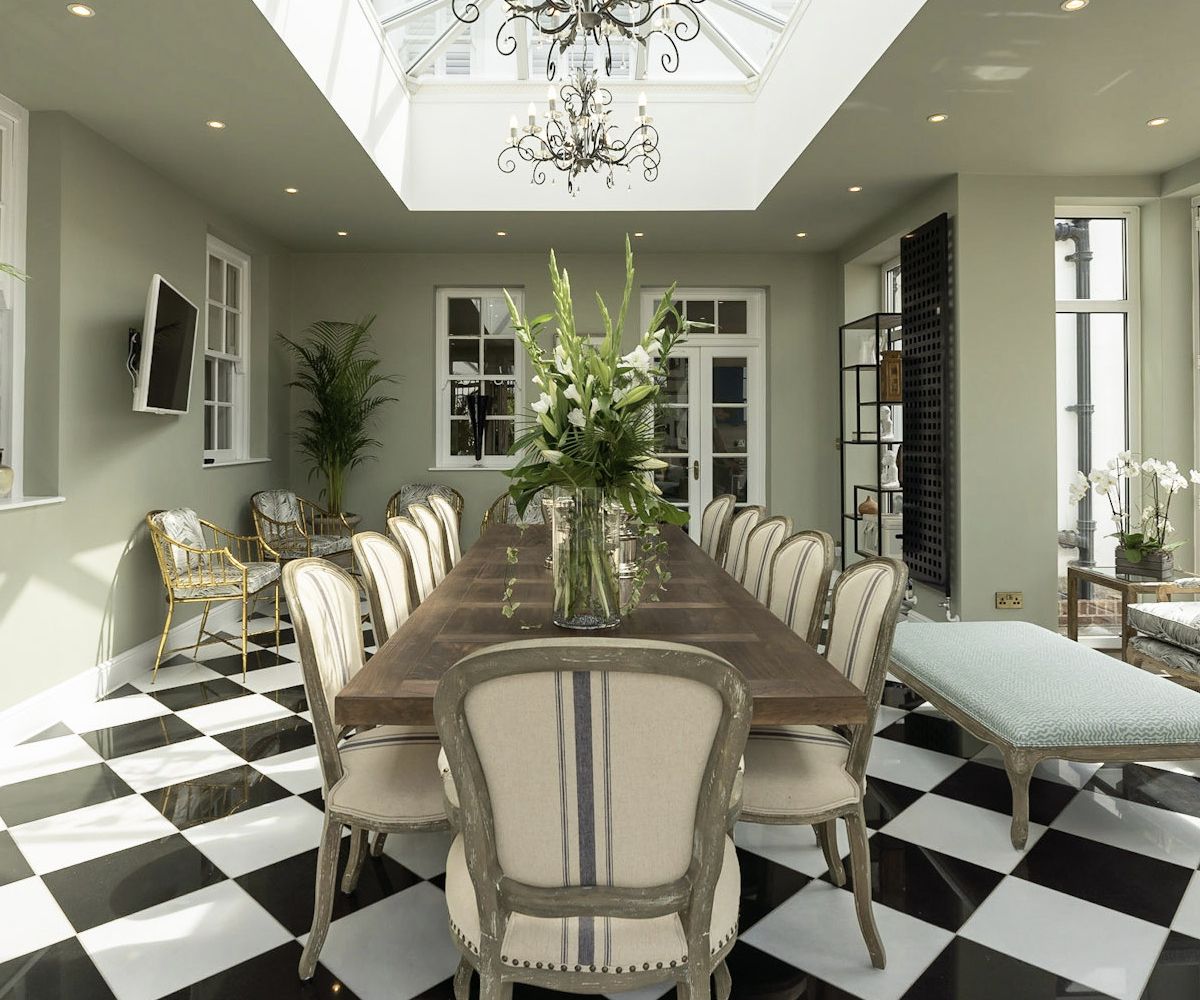 A grand formal dining room with a black and white checkered floor, chandelier and classical styling - Atlantic Interiors installation and styling