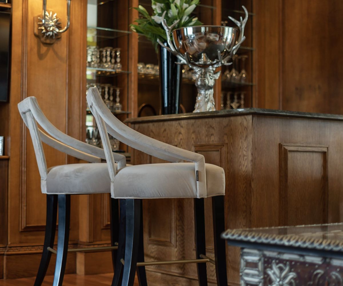 An ornately upholstered chair in a rich, detailed hospitality interior — designed by Atlantic Interiors